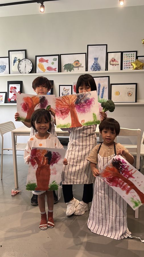 Students showing their finished paintings